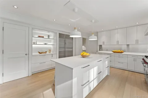 a kitchen that has a lot of cabinets and wooden floor