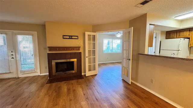 a view of a livingroom with wooden floor a fireplace and window