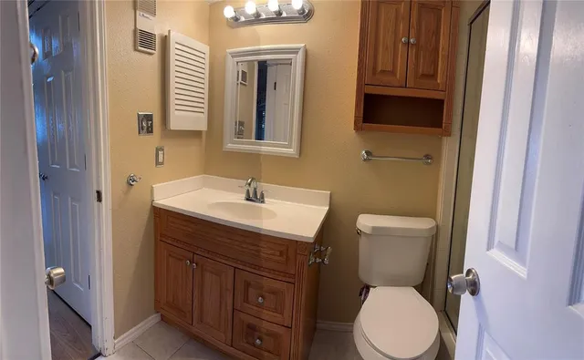 a bathroom with a toilet a sink a mirror and vanity
