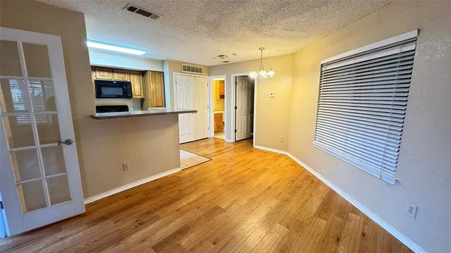 a view of a kitchen with wooden floor and a ceiling fan