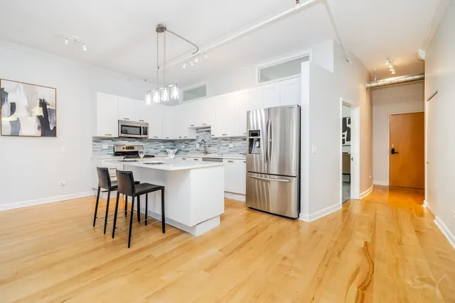 a kitchen with kitchen island a white cabinets and refrigerator