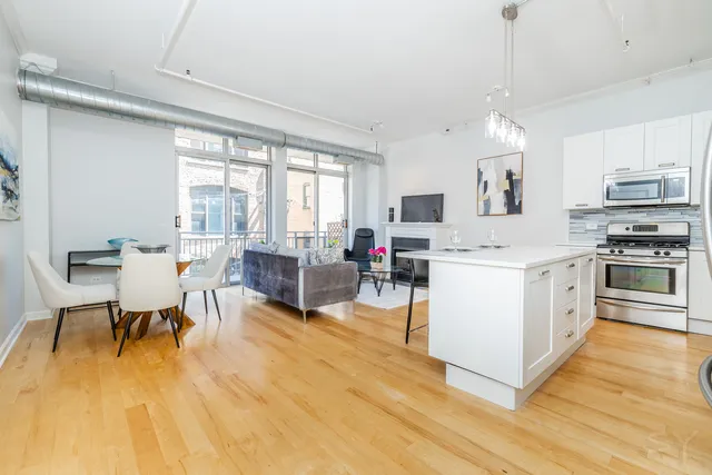 a kitchen with stainless steel appliances kitchen island wooden floors and white cabinets