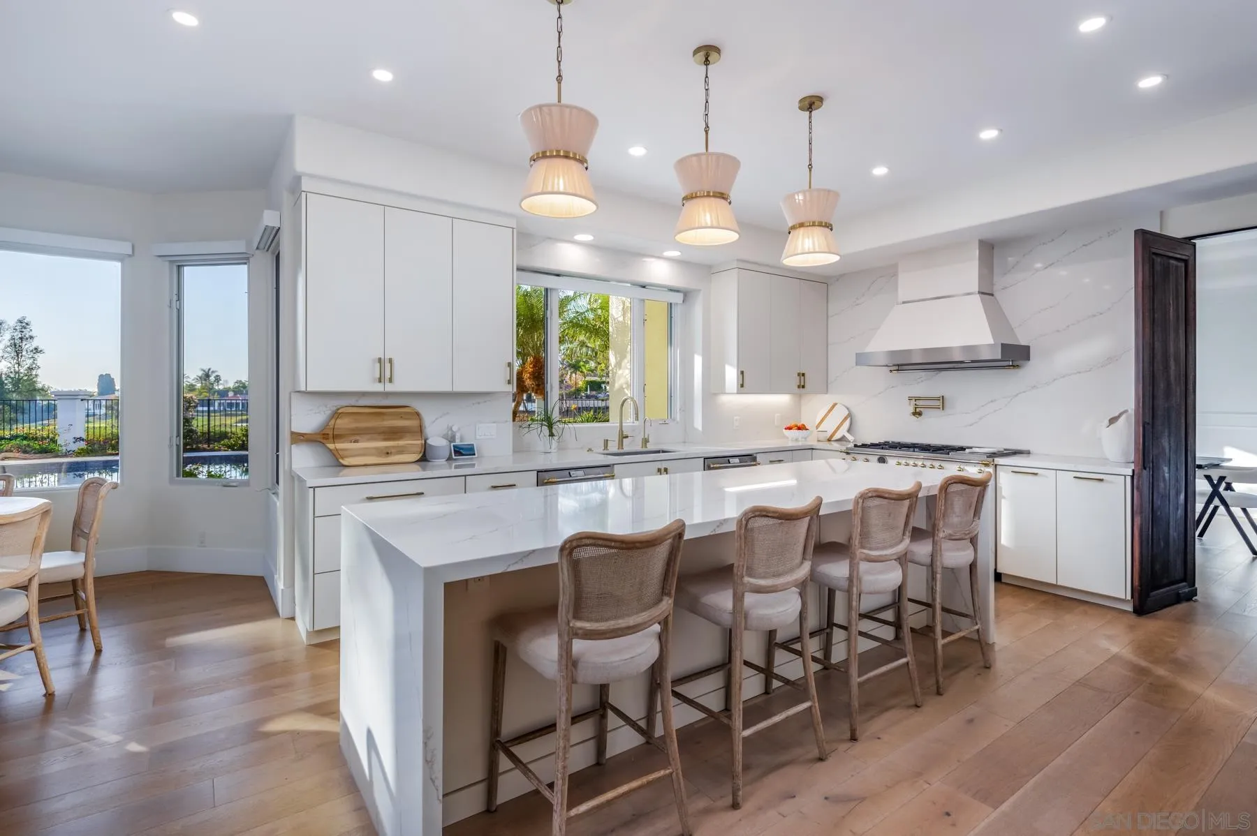 7430 St Andrews Road Rancho Santa Fe, CA 92067 - Photo 7 of 48 a kitchen with stainless steel appliances a stove a table a sink refrigerator and cabinets