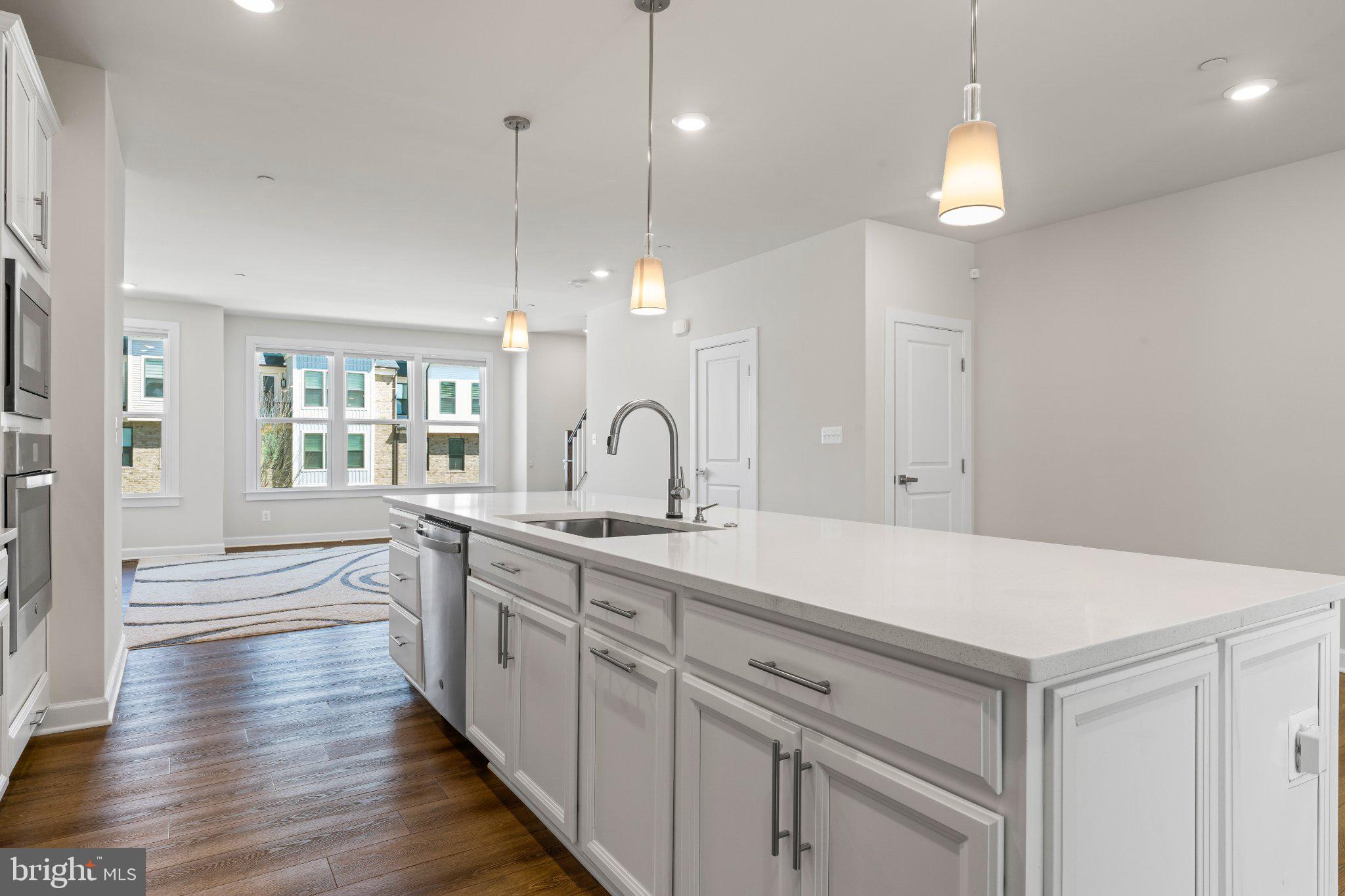 7504 Overview Terrace Columbia, MD 21044 - Photo 3 of 54 a large kitchen with kitchen island a stove a sink a center island and wooden floor