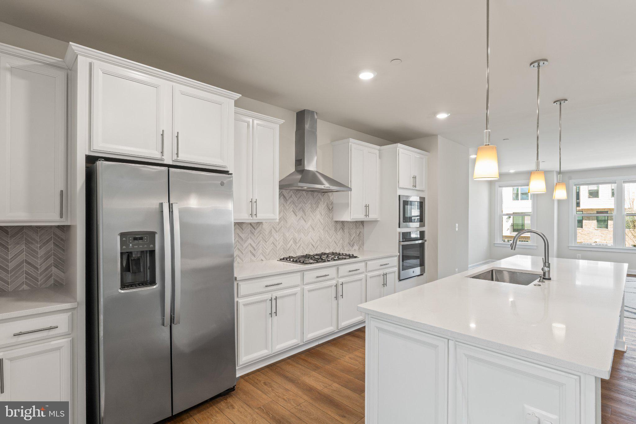 7504 Overview Terrace Columbia, MD 21044 - Photo 6 of 54 a kitchen with stainless steel appliances granite countertop a refrigerator a sink a oven and white cabinets with wooden floor