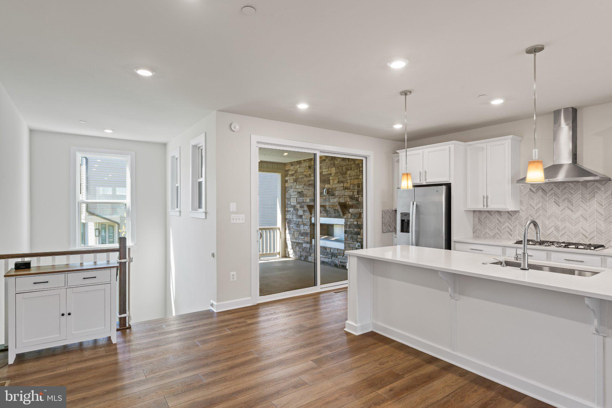 7504 Overview Terrace Columbia, MD 21044 - Photo 8 of 54 a large white kitchen with a refrigerator a sink dishwasher and a stove with wooden floor