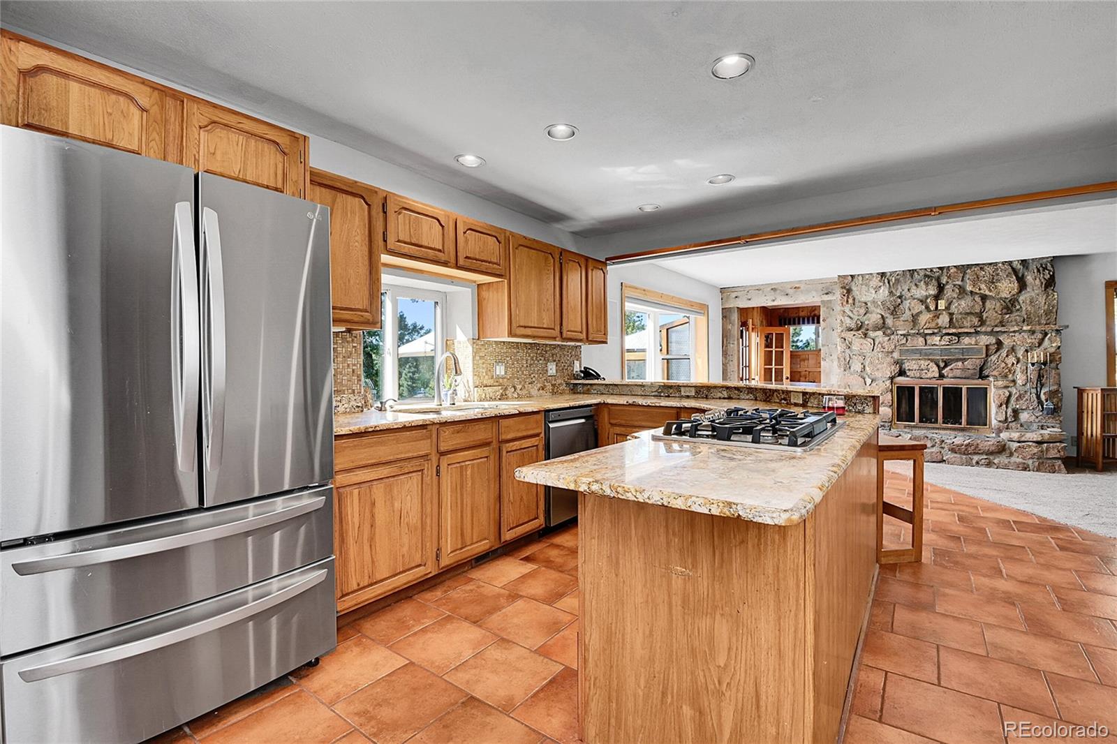 13082 South Wamblee Valley Road Conifer, CO 80433 - Photo 7 of 35 a kitchen with stainless steel appliances granite countertop a refrigerator a sink dishwasher a oven with white cabinets and wooden floor