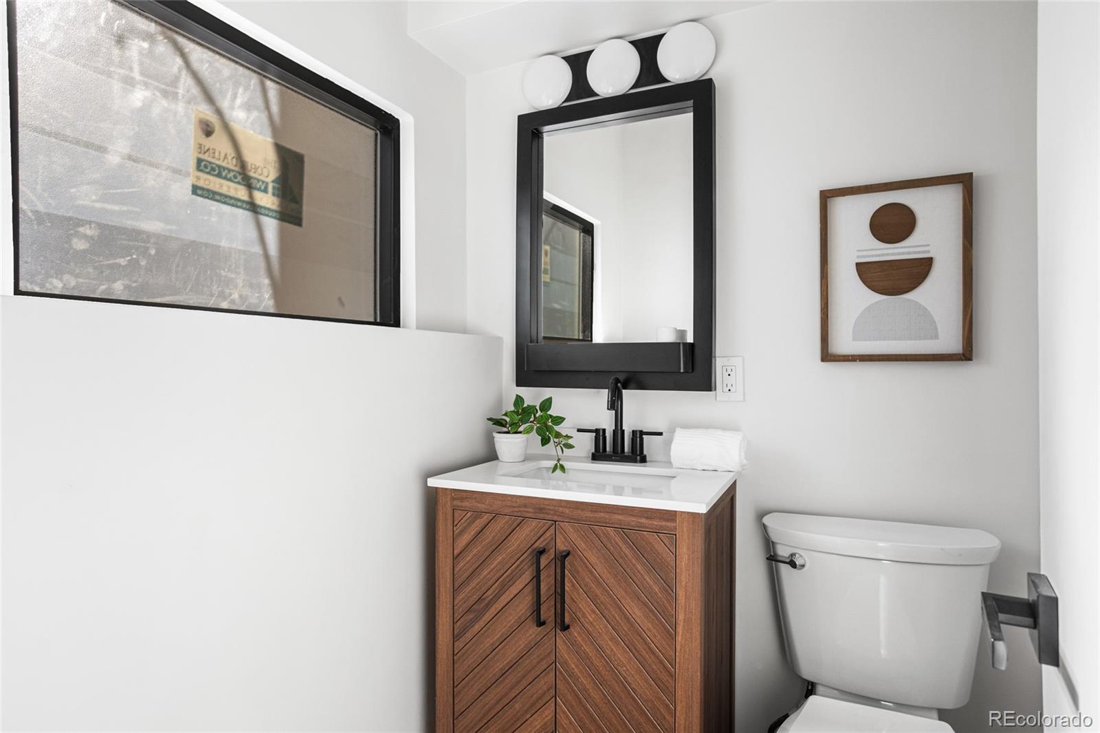 1812 South Ivanhoe Street Denver, CO 80224 - Photo 14 of 46 a bathroom with a toilet a sink and mirror