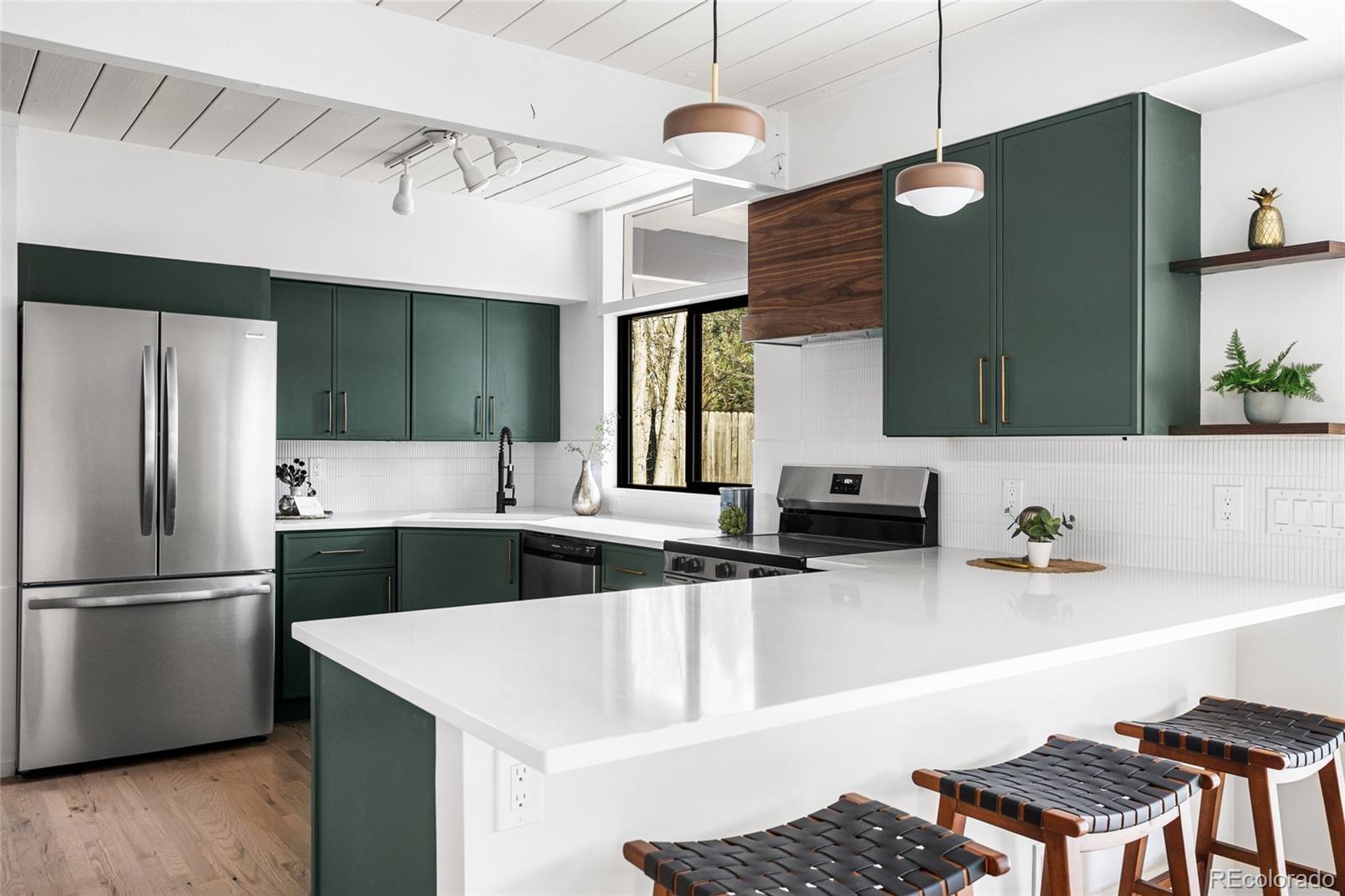 1812 South Ivanhoe Street Denver, CO 80224 - Photo 17 of 46 a kitchen with stainless steel appliances kitchen island a sink and a refrigerator