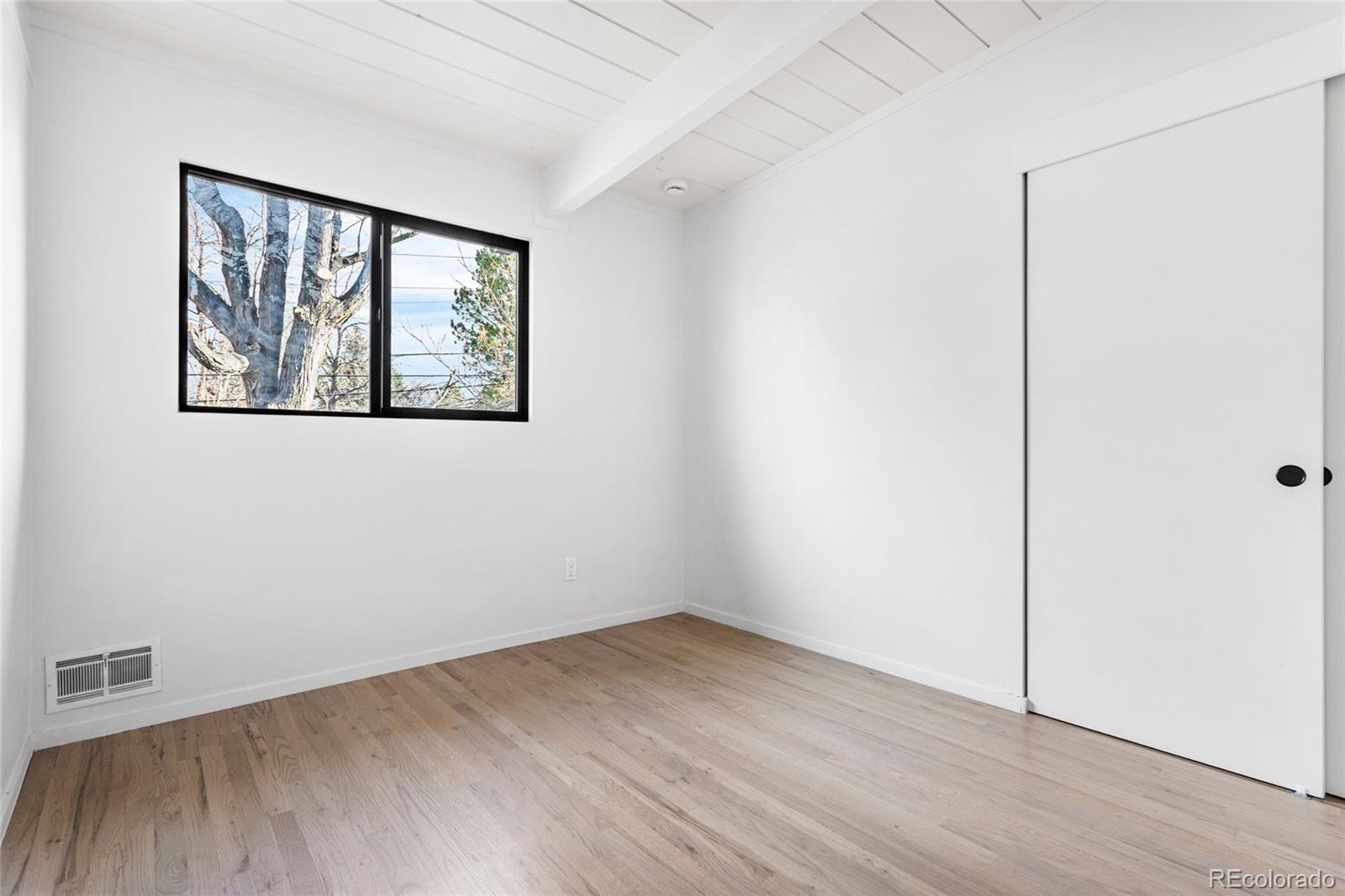 1812 South Ivanhoe Street Denver, CO 80224 - Photo 29 of 46 a view of an empty room with wooden floor and a window
