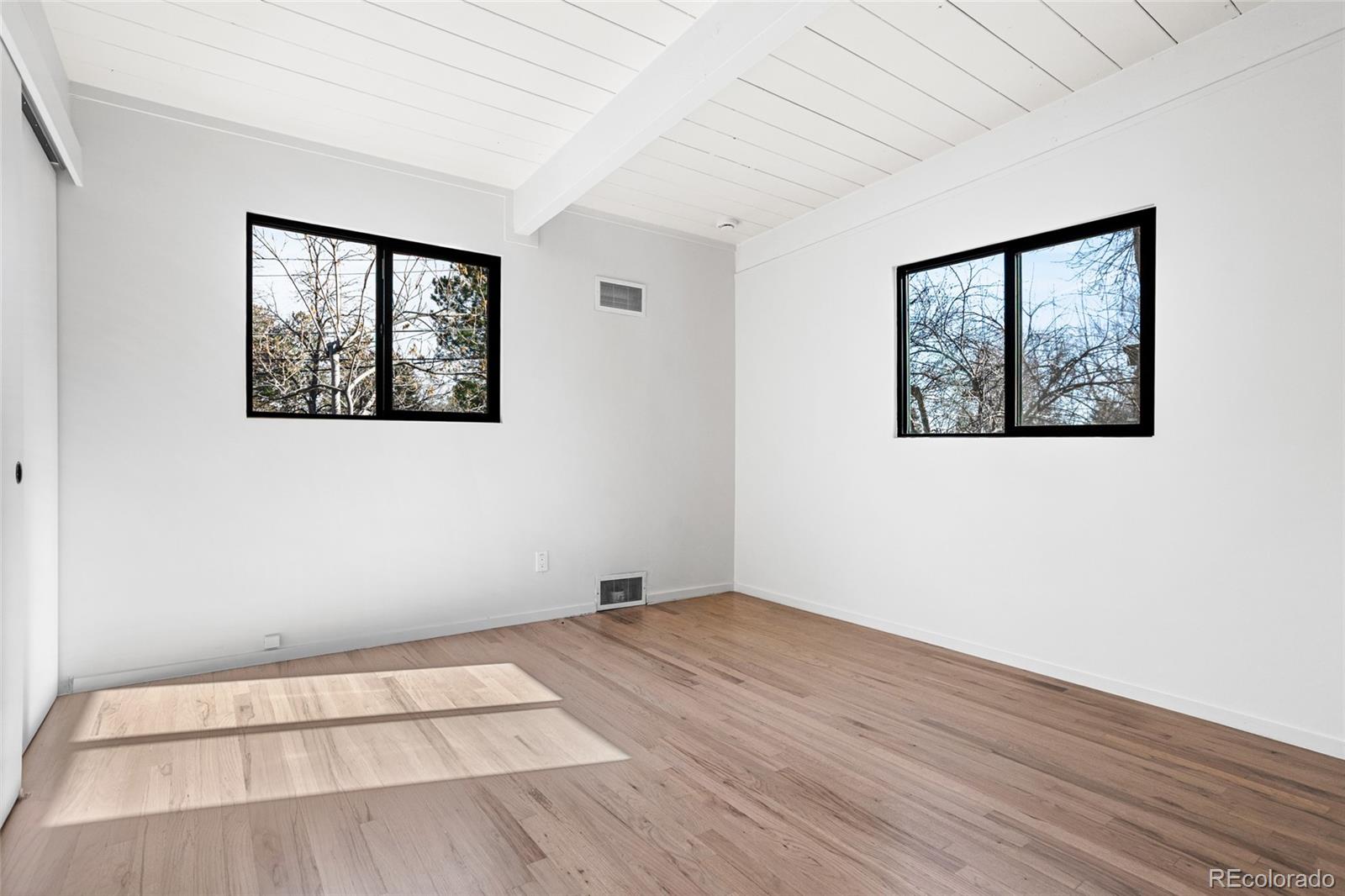 1812 South Ivanhoe Street Denver, CO 80224 - Photo 30 of 46 an empty room with a window and wooden floor