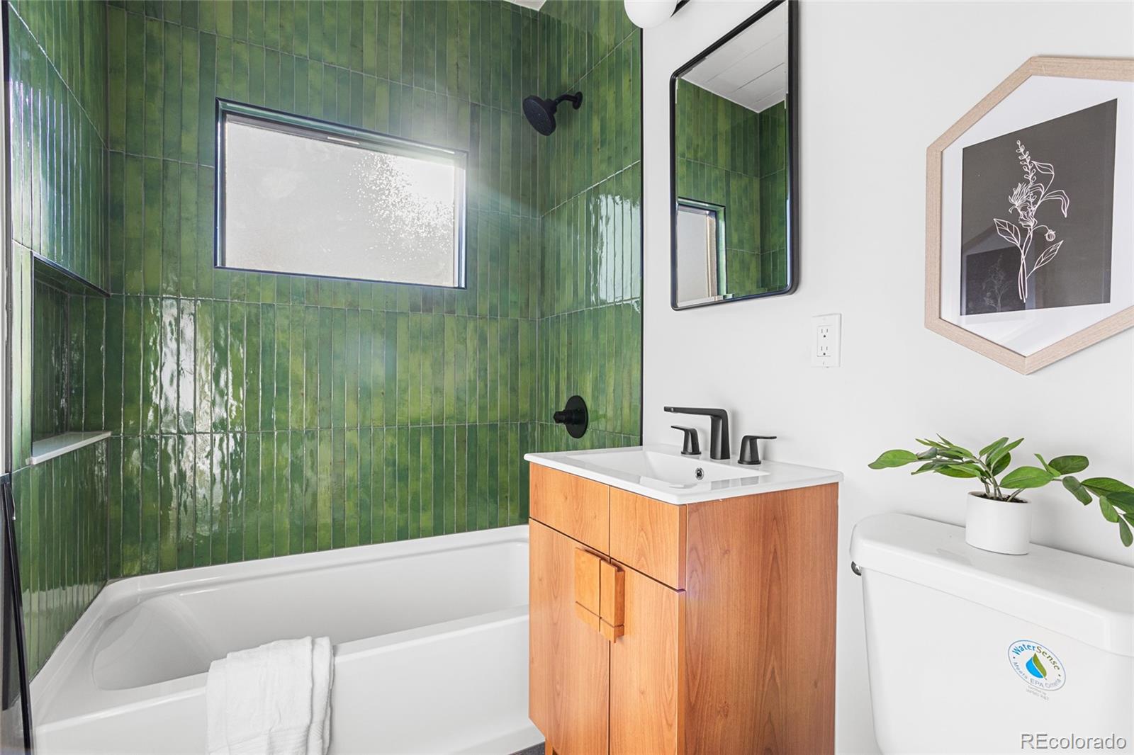 1812 South Ivanhoe Street Denver, CO 80224 - Photo 31 of 46 a bathroom with a sink a mirror and a bathtub