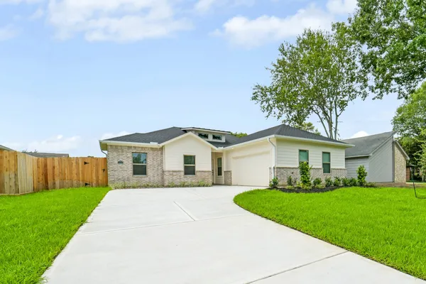 a front view of a house with a garden and yard
