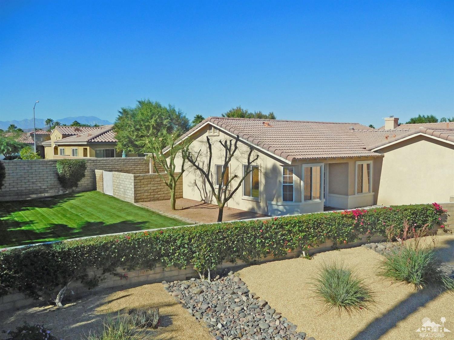49699 Truman Way Indio, CA 92201 - Photo 18 of 19 a view of a house with a yard and potted plants