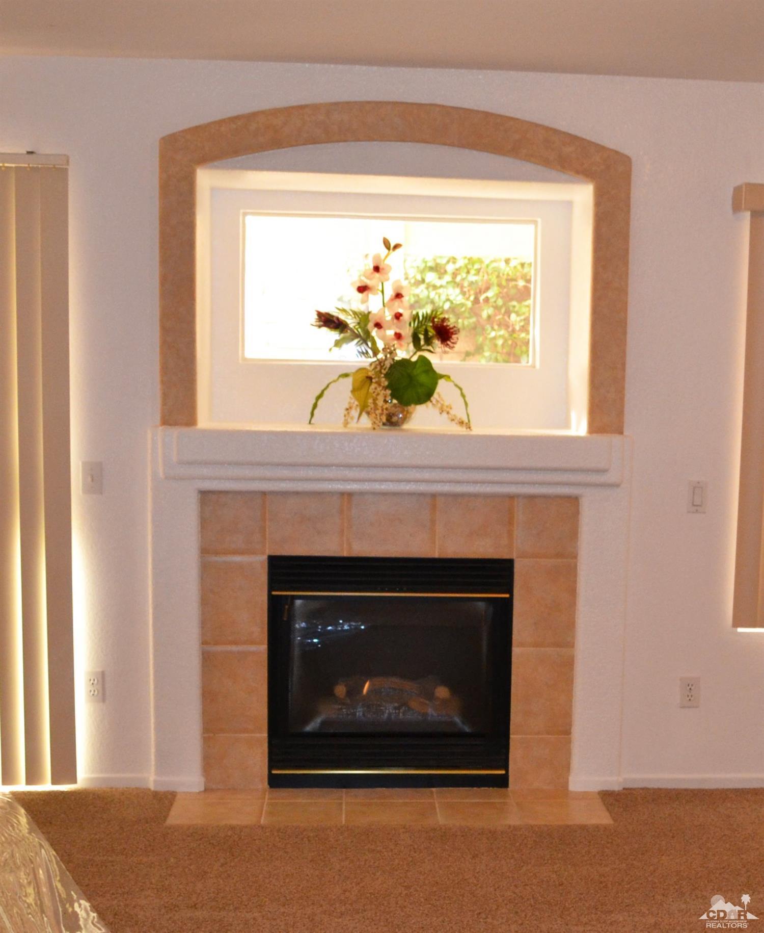 49699 Truman Way Indio, CA 92201 - Photo 5 of 19 a living room with a fireplace and a window