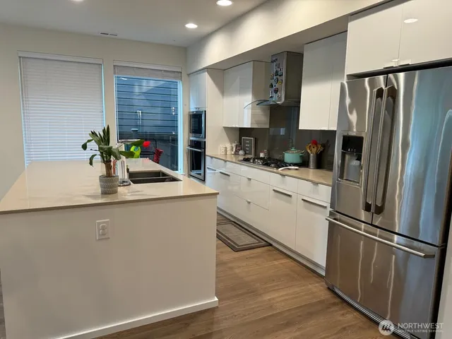 a kitchen with stainless steel appliances a refrigerator sink and microwave
