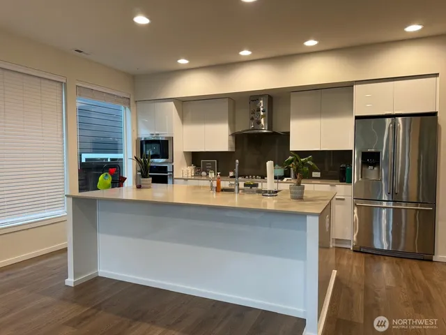 a kitchen with stainless steel appliances granite countertop a refrigerator and a sink