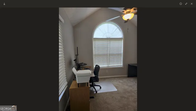 a view of a workspace with furniture and a window