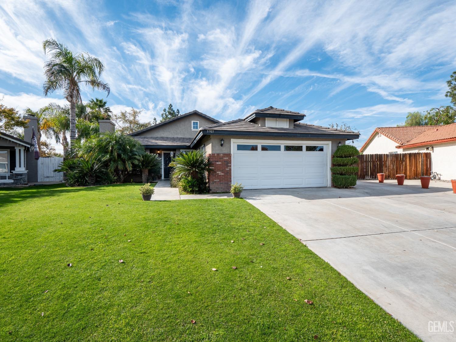 a front view of a house with yard and green space