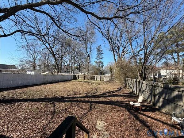 a view of a yard with wooden fence