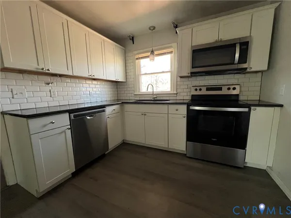 a kitchen with stainless steel appliances granite countertop a stove a microwave and a sink