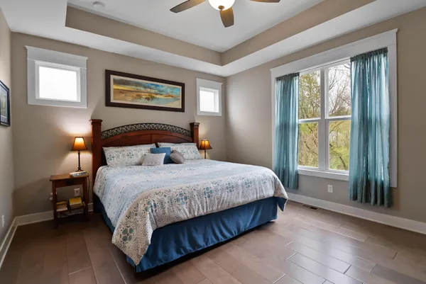 a bedroom with a large bed and a chandelier fan