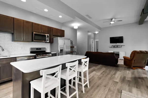 a kitchen with a table chairs refrigerator and microwave