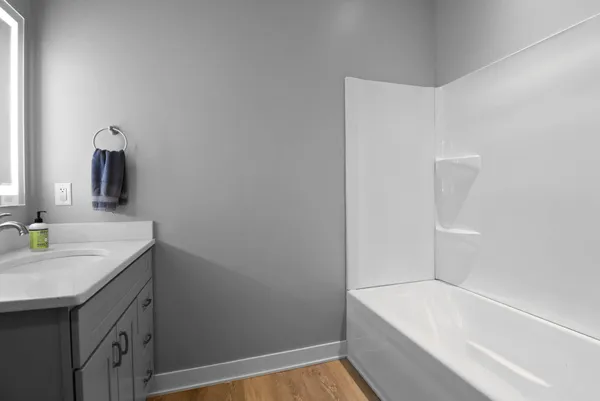 a bathroom with a granite countertop sink and a bathtub