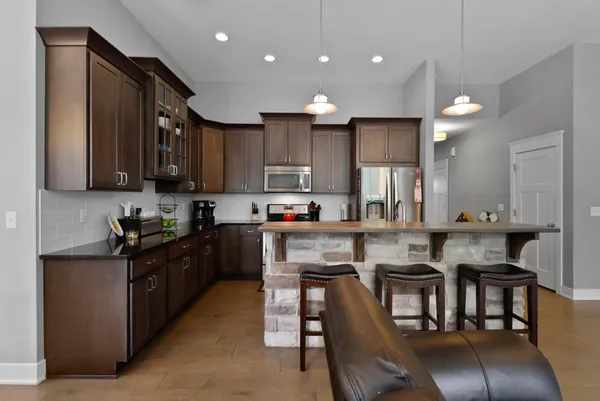 a kitchen with granite countertop a table chairs microwave and cabinets