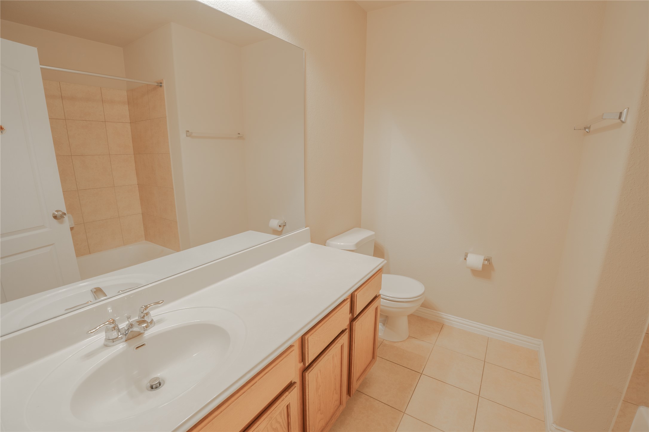 403 Tascate Street Georgetown, TX 78628 - Photo 21 of 26 A well-lit bathroom provides a tiled tub-shower combination, an extended vanity, and a large mirror.