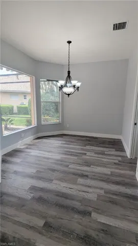 a empty room with window and wooden floor
