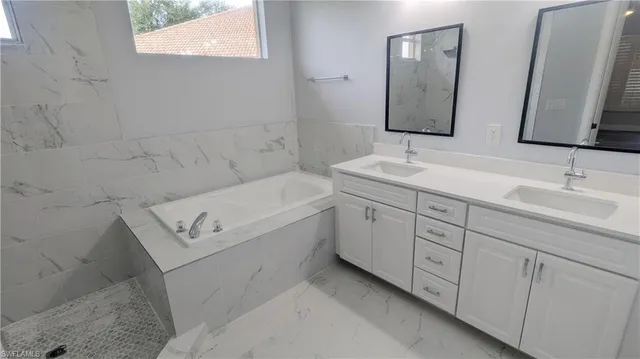 a bathroom with a tub sink and mirror