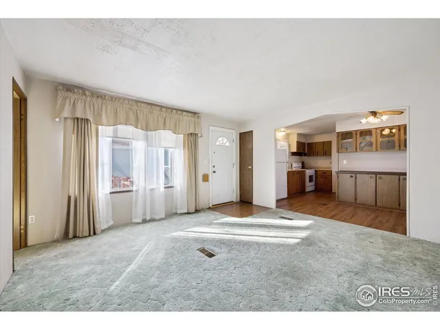 a view of a livingroom with furniture and an empty room