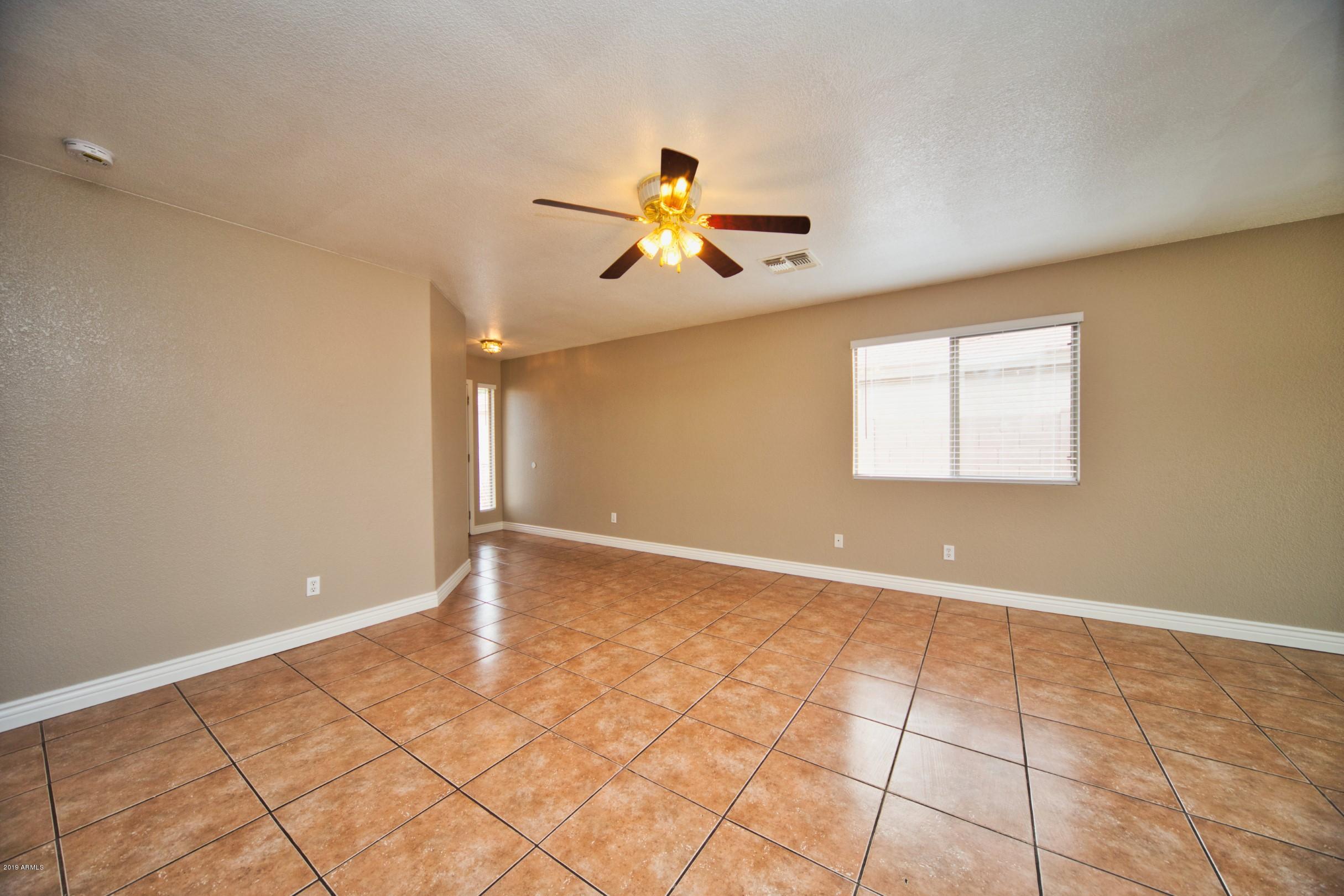 6237 West Raymond Street Phoenix, AZ 85043 - Photo 9 of 39 a view of an empty room with window and a chandelier fan