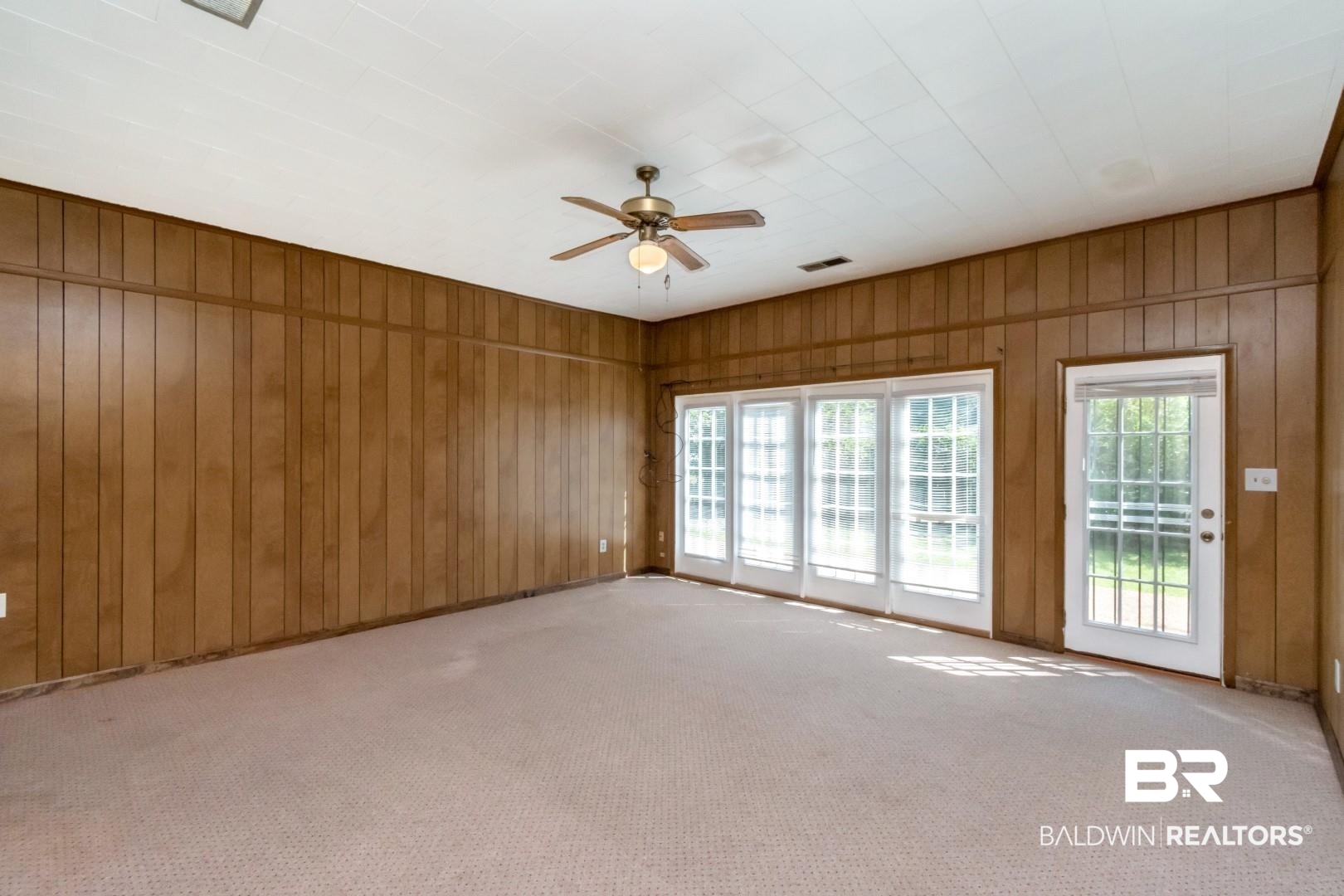 1477 Fairfield Street Mobile, AL 36606 - Photo 20 of 34 Carpeted spare room featuring ceiling fan and wooden walls