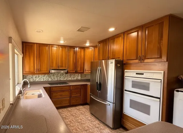 a kitchen with stainless steel appliances granite countertop a refrigerator and a sink