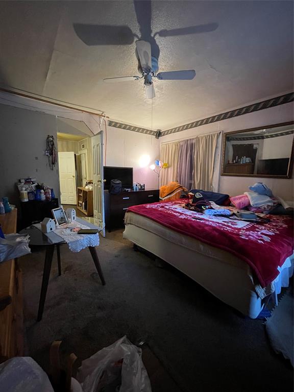 607 Neches Street Dallas, TX 75208 - Photo 5 of 12 a bedroom with a bed and a chandelier