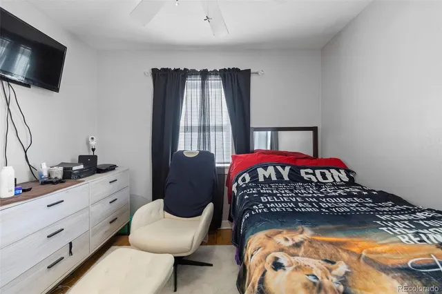 a bedroom with a bed a flat screen tv and dresser in it