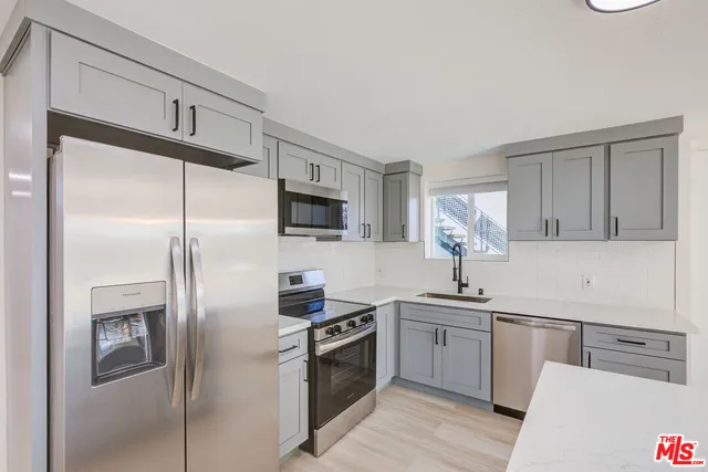 a kitchen with a sink stainless steel appliances and cabinets