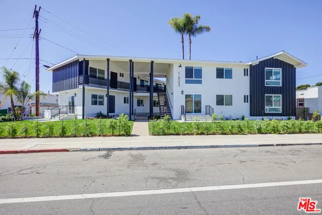a front view of a building with a garden and plants