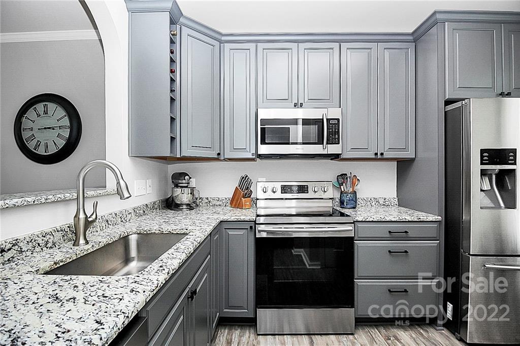 703 Shellstone Place Fort Mill, SC 29708 - Photo 3 of 23 a kitchen with granite countertop a stove a sink and a microwave