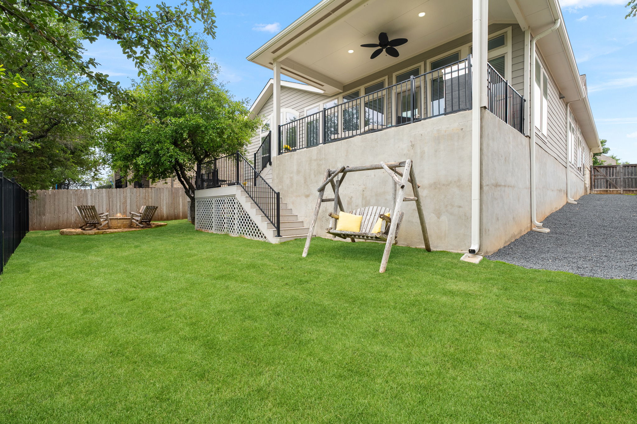 1908 Woolsey Way Leander, TX 78641 - Photo 24 of 36 A tiered outdoor living space offers a covered patio and a manicured yard with a fire pit area.