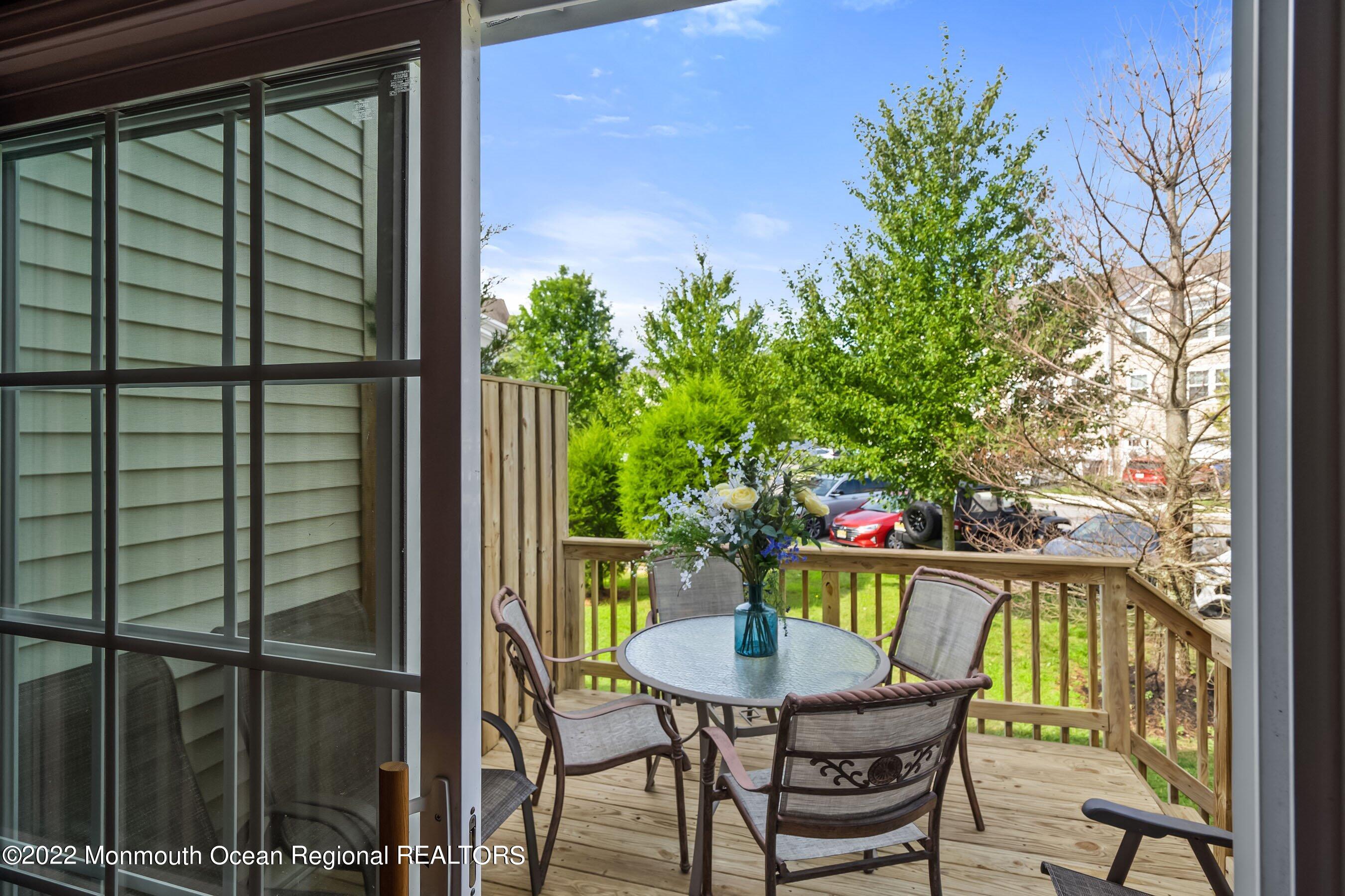 107 Bryce Lane, Unit 2004 Manahawkin, NJ 08050 - Photo 14 of 39 a view of a balcony with table and chairs and a potted plant