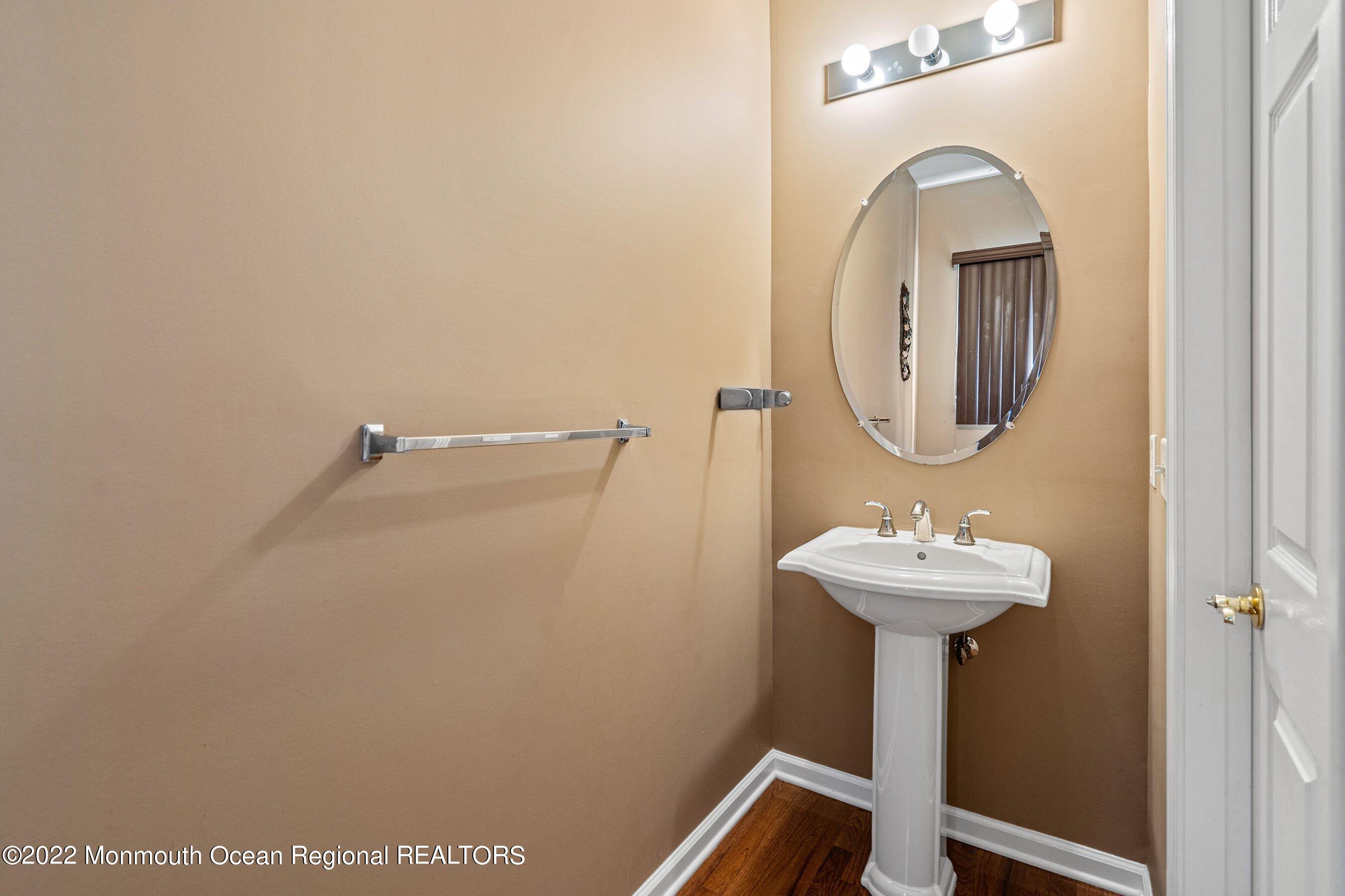 107 Bryce Lane, Unit 2004 Manahawkin, NJ 08050 - Photo 17 of 39 a bathroom with a sink mirror and toilet