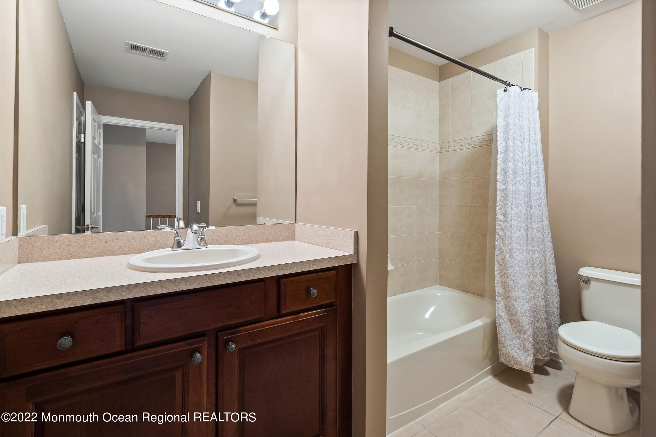 107 Bryce Lane, Unit 2004 Manahawkin, NJ 08050 - Photo 27 of 39 a bathroom with a sink a toilet and shower