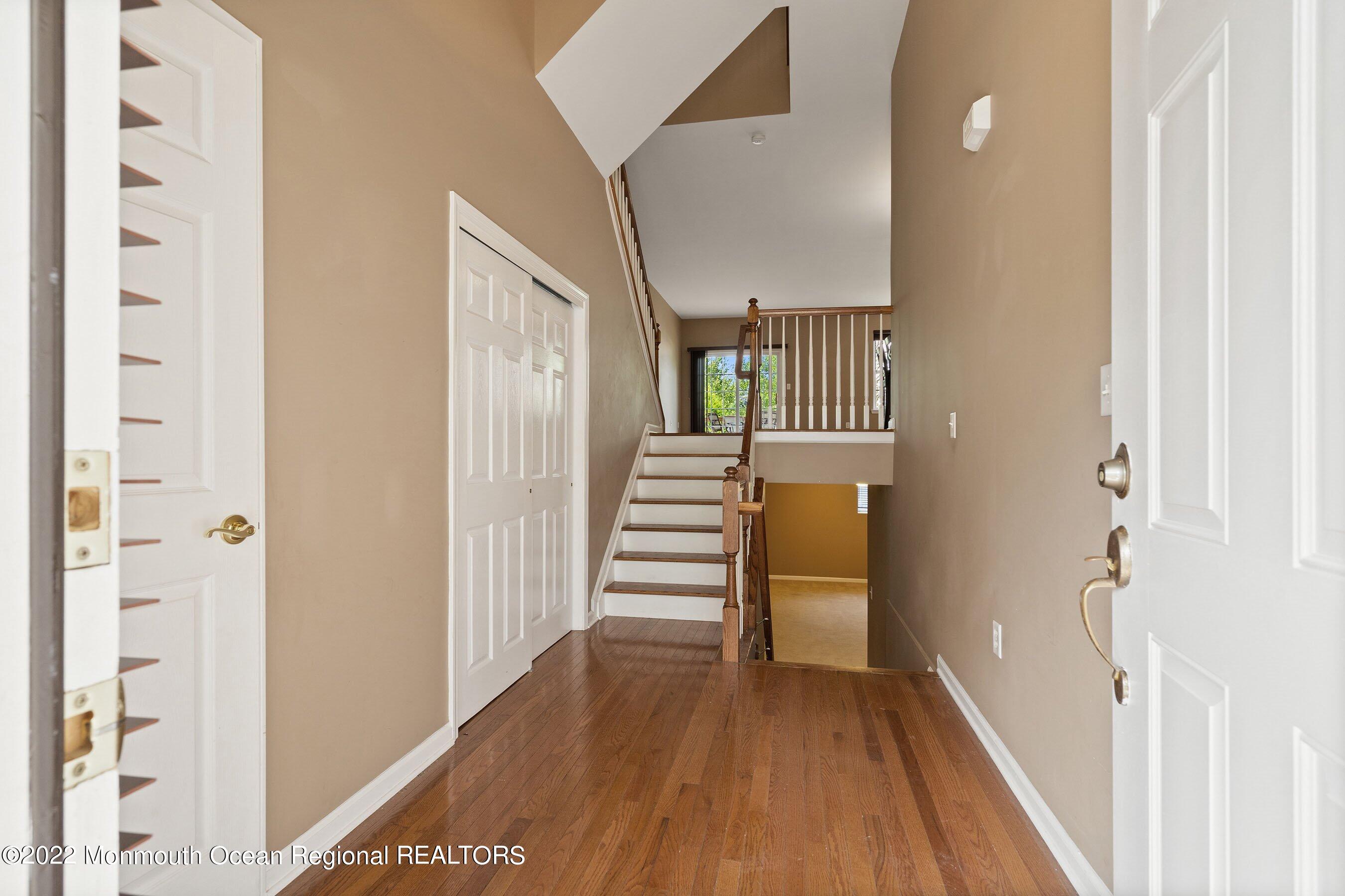 107 Bryce Lane, Unit 2004 Manahawkin, NJ 08050 - Photo 4 of 39 a view of a hallway with wooden floor and staircase