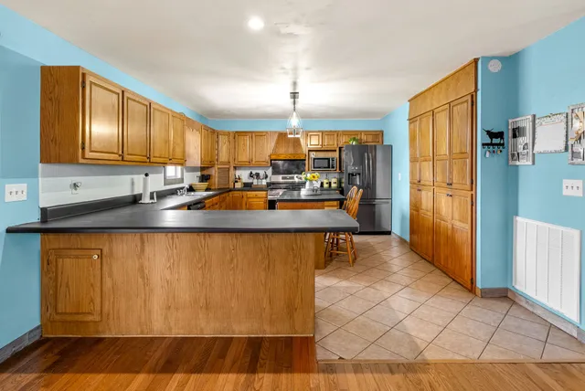 a kitchen with stainless steel appliances granite countertop a stove a sink dishwasher and a refrigerator