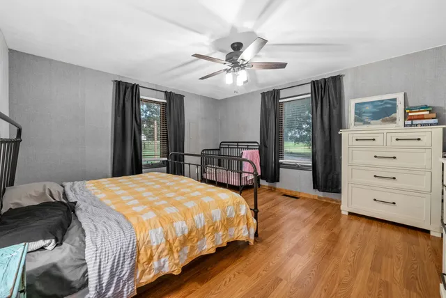 a bedroom with a bed and wooden floor