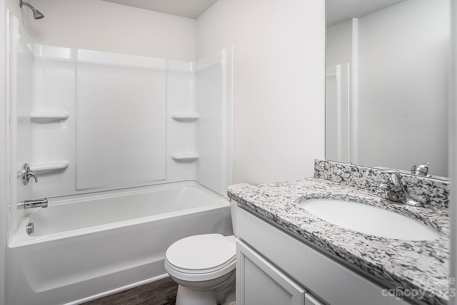 1542 Nia Road Charlotte, NC 28215 - Photo 14 of 15 a bathroom with a granite countertop toilet sink and bathtub
