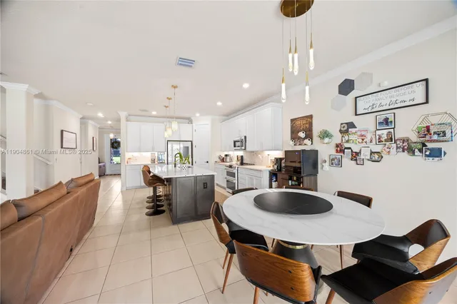 a kitchen with kitchen island a dining table and chairs